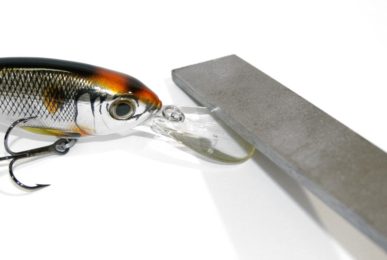 A file being used on the bill of a crankbait