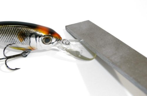 A file being used on the bill of a crankbait