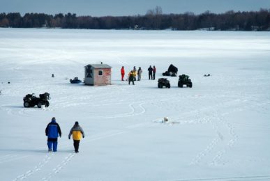 People ice fishing on a lake