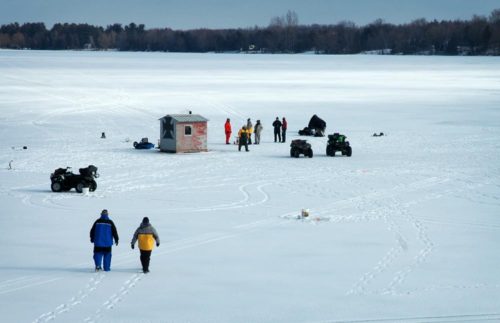 People ice fishing on a lake